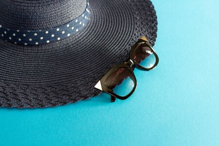 Blue hat made of fabric and sunglasses on blue background.の写真素材