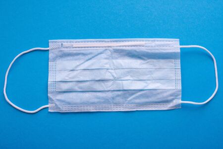 Protective medical face mask on a blue background.の写真素材