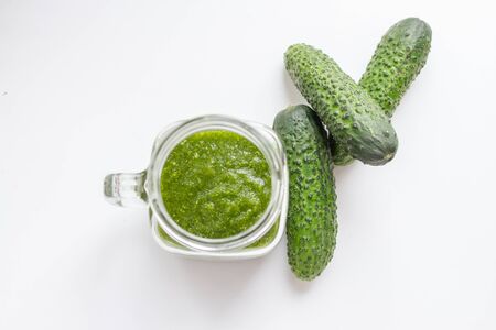 green detox smoothie in a glass jar and fresh cucumbersの写真素材