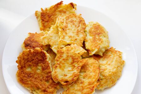 freshly fried potato pancakes on a white plateの写真素材