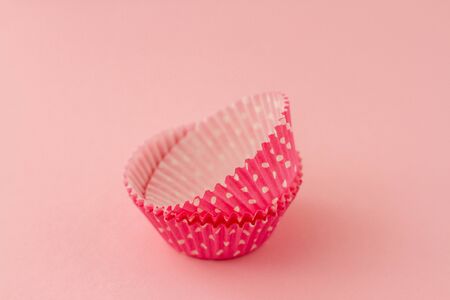 Pink empty cupcake paper case on pink background.の写真素材