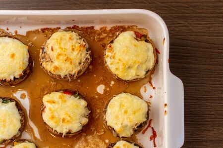 Baked stuffed mushrooms in a baking dish on a wooden table, top view.の写真素材