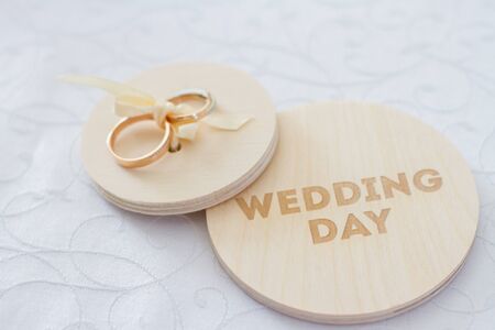 Wooden plaque and golden rings for the decor with the inscription Wedding day .の写真素材