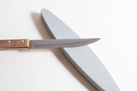Kitchen knife with wooden handle and whetstone.の写真素材