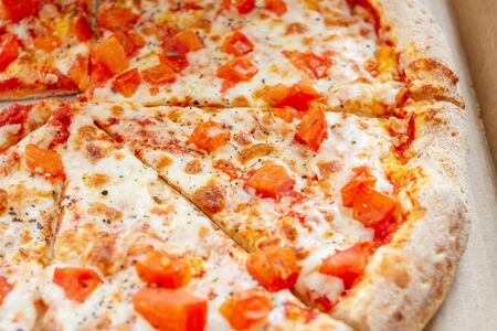 Sliced Pizza With Tomatoes. Vegetarian Italian pizza with melted cheese, red tomatoesの写真素材