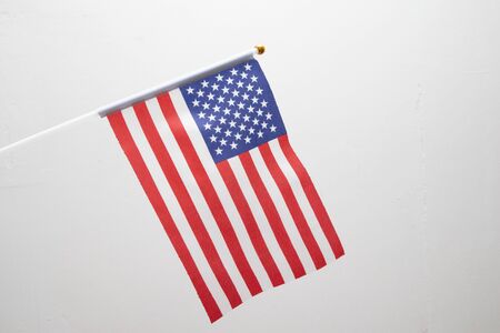 Small American flag on stick. United State of America flag on white background. USA patriotic Concept.の写真素材