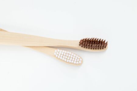 Two bamboo toothbrushes on a white background.