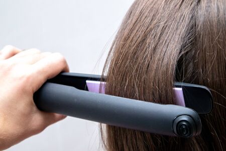 Hairstylist straightening the hair. Professional ultrasonic iron tool.の写真素材