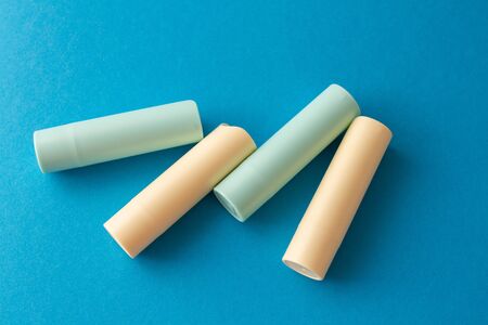 Sets of hygienic lipsticks on a blue background.