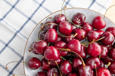 Fresh sweet cherries with water drops in bowl. Close-up, top view