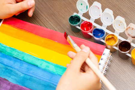 Girl`s hands drawing rainbow picture in times of coronavirus.の写真素材