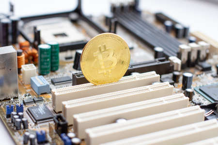 Golden Bitcoin on the circuit main computer board. Electronic currency