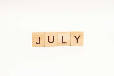 Word JULY made of wooden blocks on white background. Month of year.の写真素材