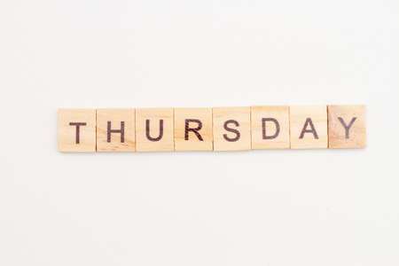 Word THURSDAY made from wooden cubes on white. Days of the week.の写真素材