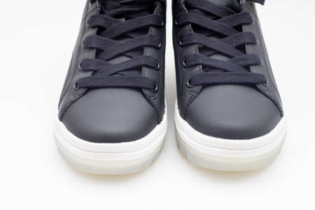 Pair of new black sneakers with white sole on white backgroundの写真素材
