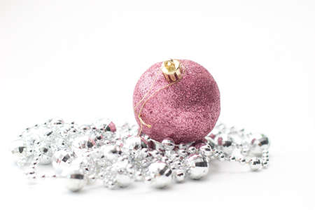 Christmas pink shining ball and silver garland. Christmas ornaments on white background.の写真素材
