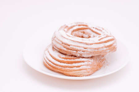 Cottage cheese bagels cakes sprinkled with sugar on a white plate.