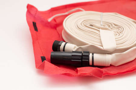 Rolled up firefighter hose reel on red bag.の写真素材