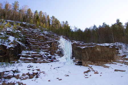 Rock climbers climb a frozen ice waterfallの写真素材