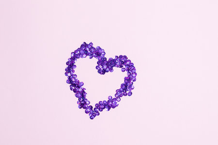 Purple confettis in the form of heart on pink background. Valentines Day decorの写真素材