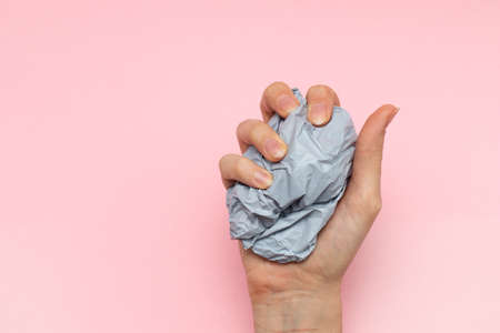 Female hand squeezes a plastic bag with trash in handの写真素材