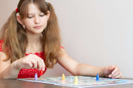 Little girl playing on board game. Selective focus.