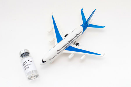Concept of Traveling during covid-19 pandemic. Vial with Coronavirus vaccine and airplane model.