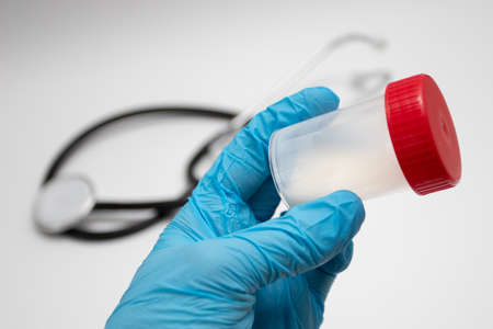 Doctor holding a plastic jar with sperm for semen analysis. Medical test in hospital. Semen analysis in a Bank. Donor Sperm. Man health concept.の写真素材