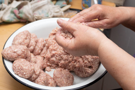 Hands making minced meat cutlets. Preparing meatballs with raw mincemeat.の写真素材