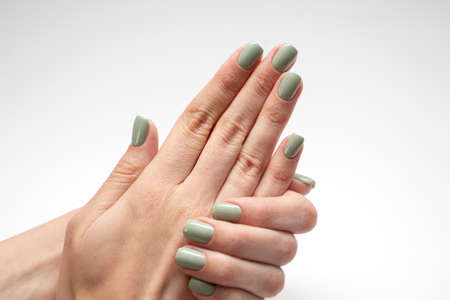 Beautiful womans hands with green nail. Fresh manicure isolated on white backgroundの写真素材