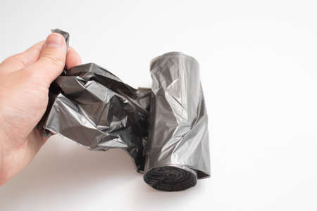Roll of plastic garbage bags in hand.