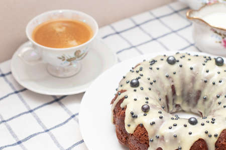 Cup of cappuccino and Round Easter homemade cupcake with white icing. Freshly baked homemade protein...