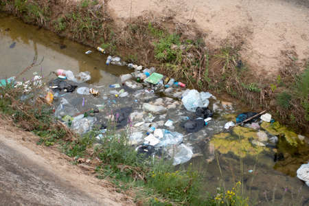 Polluted water and garbage in channel.
