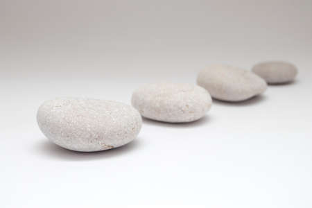 a row of smooth pebbles on white background.の写真素材