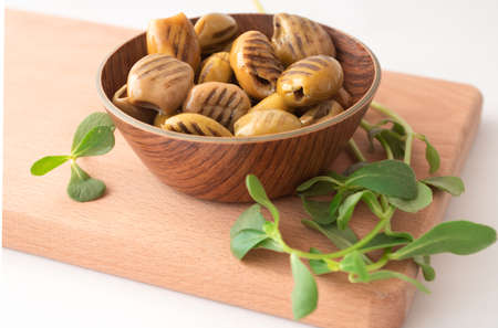 Grilled pickled green olives in wooden bowlの写真素材