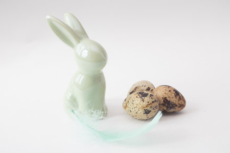 Easter porcelain rabbit with feathers and quail eggsの写真素材