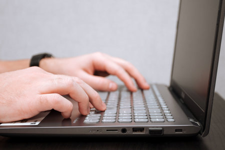 Man is typing on a laptop