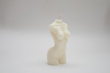 Candle figure of a torso on a white background with a shadow.の写真素材