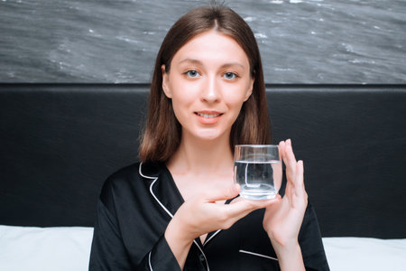 Young woman drinking water from a glass of water, closeup. healthy lifestyle