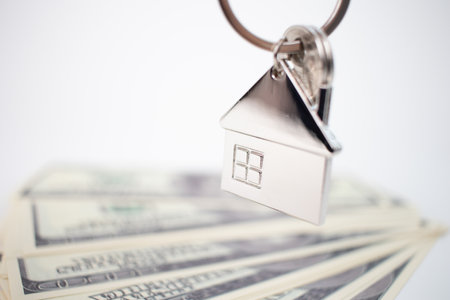 Metal keychain in the shape of a house with dollar bills