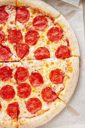 fresh pepperoni pizza on baking paperの写真素材