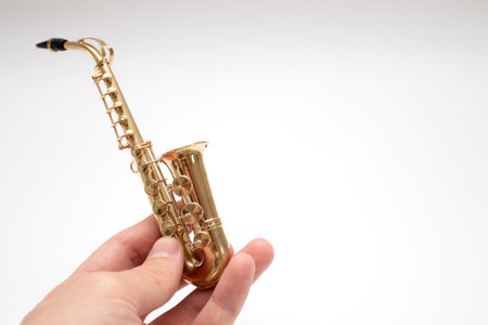 Model of toy bronze saxophone on handの写真素材