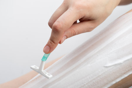 Young woman shaving her legの写真素材