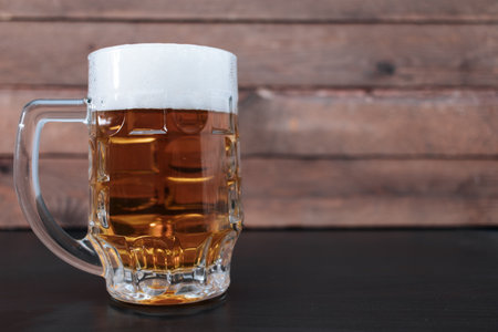 Light beer in a large glass on a wooden background.の写真素材