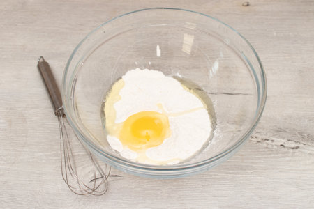 Flour in a bowl, egg and whisk. Preparation of the doughの写真素材