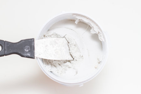putty knife on tub of white acrylic glazing puttyの写真素材