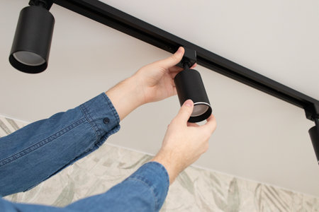 A man install a spot track LED light in the ceilingの写真素材