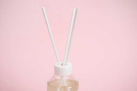 Glass jar for aromatic diffuser on pink background.の写真素材
