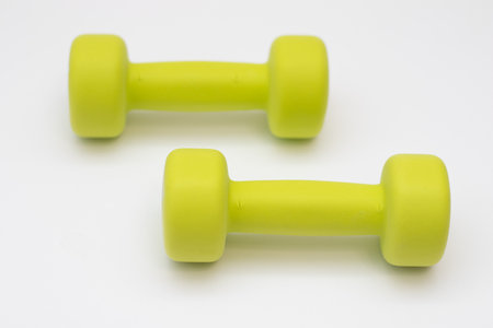 Green dumbbells on a white background good health concept.の写真素材