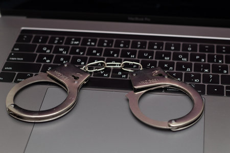 online fraud on the internet. handcuffs on the keyboard.